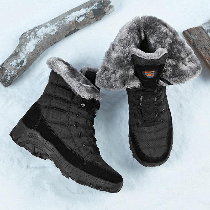 a pair of black boots sitting on top of snow covered ground