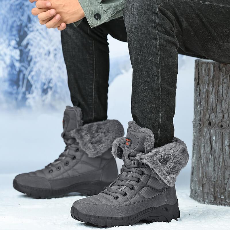 a man sitting on a tree stump wearing winter boots